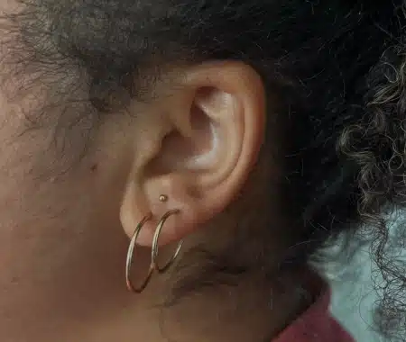 Lobe and helix piercings with gold jewelry done at Aurilus in American Fork